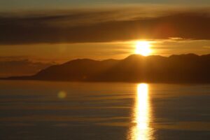 golden sunrise behind mountains, gold standard year