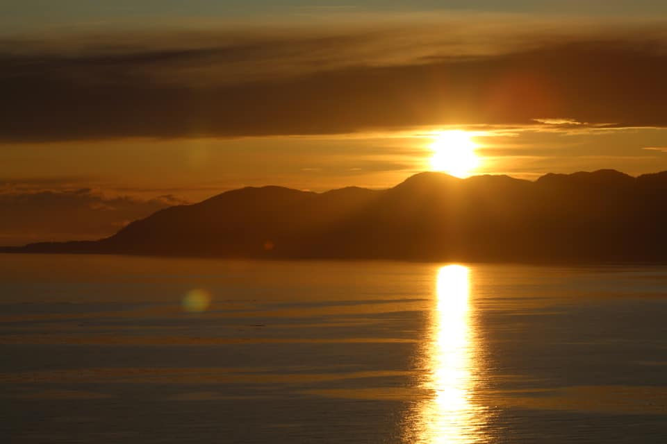 golden sunrise behind mountains, gold standard year