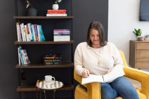 Heather Deveaux writing in a notebook, start and finish a romance novel